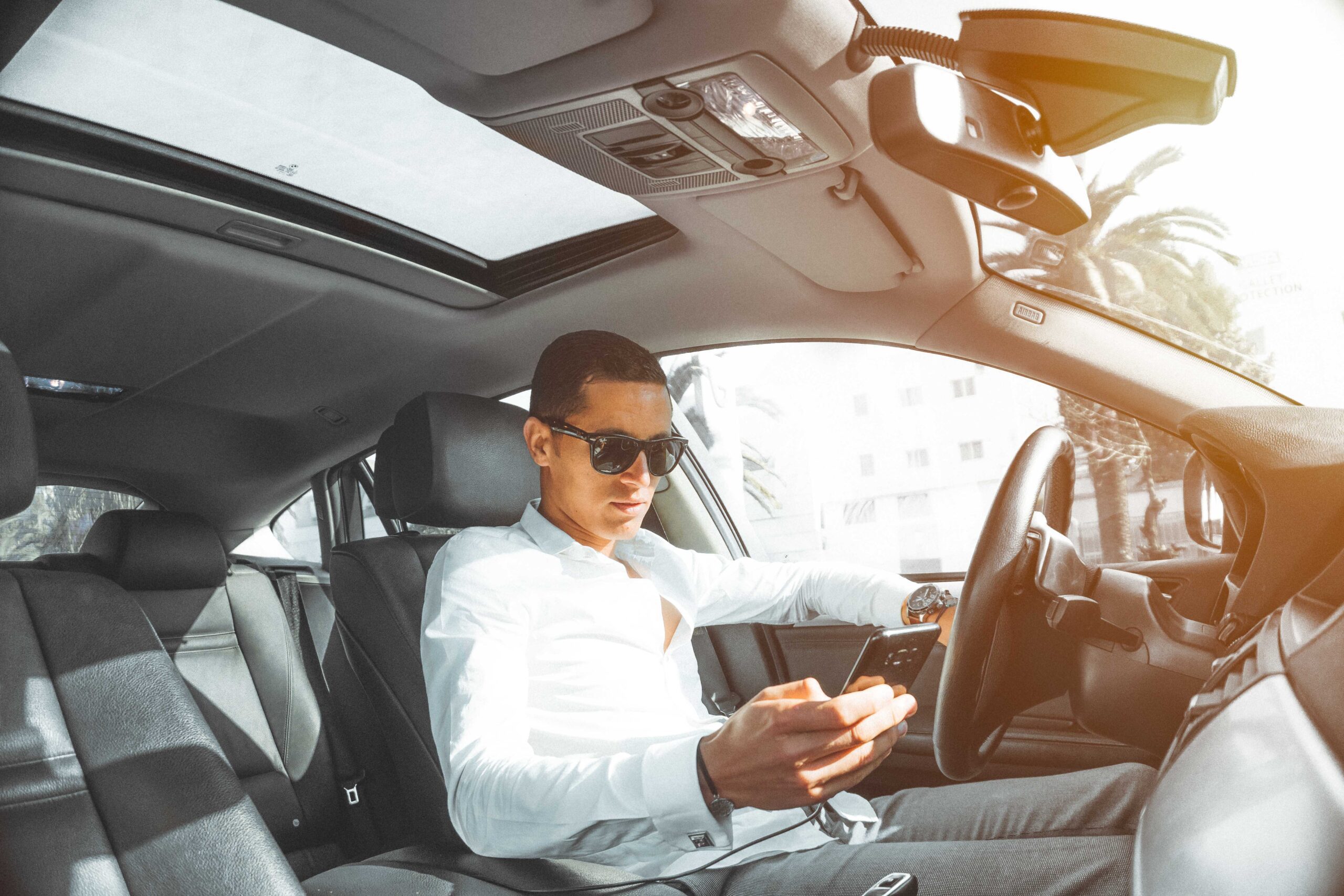 man in white shirt holding a smartphone