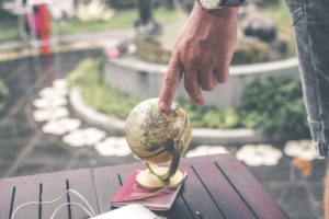 dude touching a small, gold globe