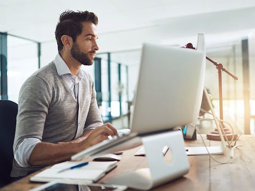 man working at his desk on his computer