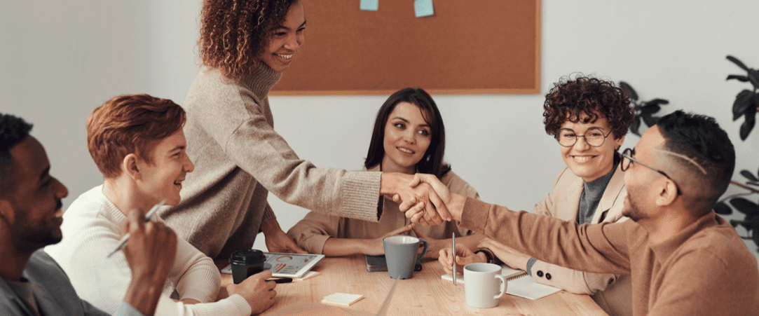 Conference table with people shaking hands and having a meeting